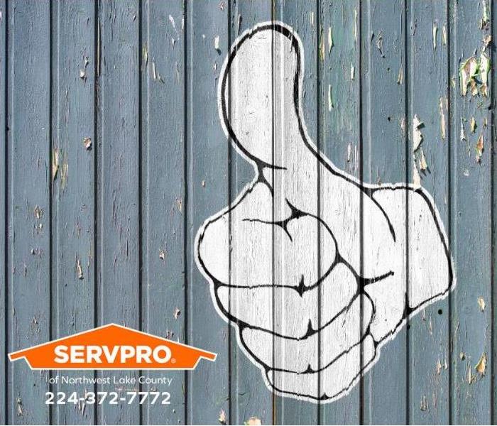 A “thumbs up” sign is painted on a wall.