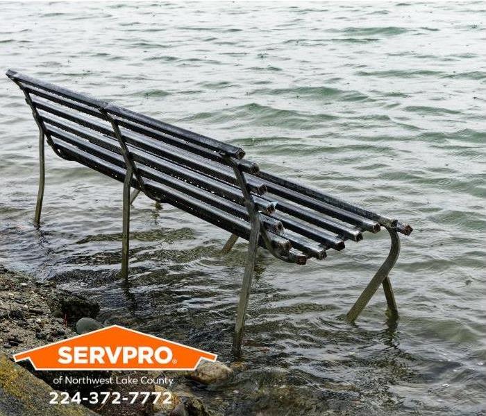 A park bench sits in flood waters.