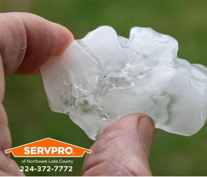A person holds a large hailstone.